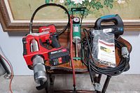 Full view of all items showing Bauer air grease tool, green air cylinder, rotary cutting tool, extension cord, instruction manual and packaging bag.