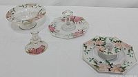 Four hand painted glass pieces including two-tier serving tray with handle, glass candlestick, fluted bowl, and pedestal dish all decorated with pink Azalea flowers and green leaves.