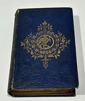 Blue cloth hardcover book with gilt decorative front cover and spine lettering shown closed.