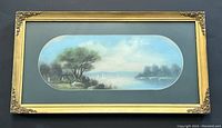 Framed antique pastel on paper river scene showing gold ornate frame with floral corner decorations and blue matting.