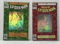 Front view of two Marvel comics in protective sleeves: Spider-Man #26 with green hologram cover and Web of Spider-Man #90 with red hologram cover, both 30th Anniversary Special Editions.