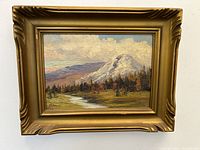 Frontal view of the oil painting showing mountain landscape and ornate gold frame