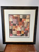 Full view of the framed abstract print with muted colors and geometric design.
