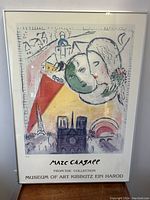 Framed poster showing full Marc Chagall artwork with various abstract figures and Paris landmarks.