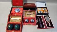 Iron exercise balls in red Chinese motif boxes with instruction paper, plus cloisonné vanity set with mirror and comb in case