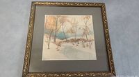 Full view of the framed watercolor artwork showing the stream and forest with fall colors and ornate frame.