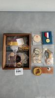 Overall view of collection in box with various pins and ribbons