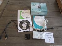 Overview of camera, battery, cables, manuals, CD, box, strap