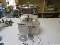 5.7 liter stainless steel chafing dish on box with accessories and fuel holder.