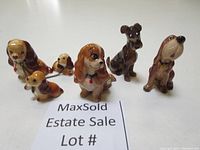 Photo showing six Disney Lady and the Tramp ceramic dog figurines arranged in a row on a white surface.