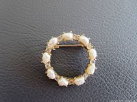 Top close-up image showing the circular brooch with nine freshwater pearls and small rhinestones in a gold-tone setting.