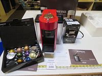 Full lot display showing Nespresso Vertuo coffee machine, Aeroccino3 milk frother box, and a black capsule box with assorted capsules.