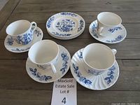 Four cups with matching saucers and dessert plates, all decorated in blue floral Indian Tree pattern on white ironstone.