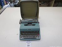 Vintage light blue Olivetti Lettera 32 typewriter with full keyboard and visible red key.