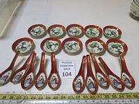Full view of the 10 small bowls and 10 matching porcelain spoons with reddish-brown borders and hand-painted figures.