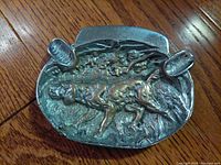 Top view of the antique ashtray showing the cast hunting retriever dog sculpture and two cigarette holders.