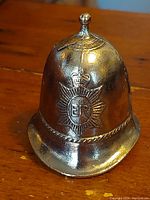 Front view of the brass Metropolitan Police ER helmet bell showing detailed crown and ER badge insignia.