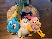 Group photo of five Angry Birds stuffed toys on a woven mat showing different characters and colors, highlighting condition and variety.
