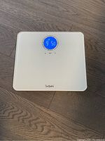 Top view of white Surpahs digital bathroom scale with blue circular digital display showing weight reading 95.8