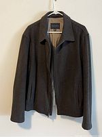 Front view of a men's wool blend jacket hanging on a hanger, showing the color, style, and zipper.