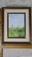 Framed oil painting showing whole artwork in 10x8 inch gallery frame, landscape of grass and fence posts with light blue sky.
