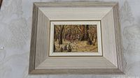 Full view of framed painting showing winter sleigh ride scene with horses and riders in a forest setting.