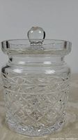 Clear Waterford crystal biscuit barrel with detailed crosshatch and starburst cuts and faceted round knob on lid.