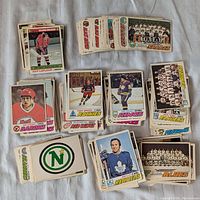 Overview of multiple stacks of 1977 O-Pee-Chee hockey cards with various NHL teams and players visible.