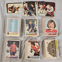 Multiple stacks of 1977-78 O-Pee-Chee NHL hockey cards including player cards and team photos, showcasing front designs and team logos.