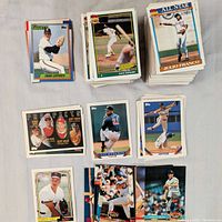 Stacks of baseball cards showing various players including Craig Lefferts, Dave Stewart, Julio Franco, and others. Cards feature typical early 1990s Topps design with action shots, team logos, and player names.
