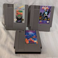 Three NES game cartridges on white fabric background, clearly showing labels for Life Force, The Punisher, and Tetris.