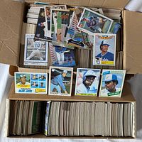 Open box showing a large quantity of Toronto Blue Jays baseball cards from Topps, spanning multiple years. Cards include various player portraits and action shots with classic and modern designs.