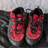 Pair of red and black Gaia Ultimate cleats size 10, showing front and toe wear.
