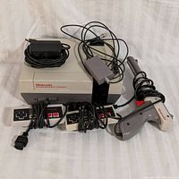 NES console, two controllers, Zapper light gun, AC adapter and RF switch modulator shown together