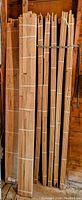 Eight bundles of 1 inch wide oak strips standing upright, bundled with white straps, showing the quantity and size of the flooring pieces.