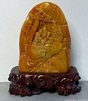 Front view with carved wooden stand beneath stone carving