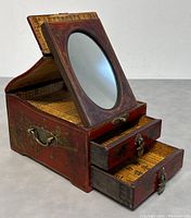 View of the box with flip-up mirror opened and two drawers partially open showing Asian script paper lining inside.