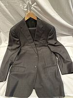 Front view of the Corneliani dark grey suit jacket showing two-button closure and flap pockets