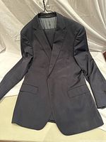 Front view of navy blue pinstripe Hugo Boss suit jacket size 42R, showing single-breasted design and flap pockets