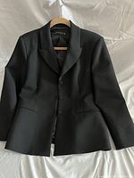 Front view of the black Zara blazer with three-button closure and lapel collar, showing a slightly tailored fit.