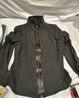 Front view of Elie Tahari black zip-up sweater with high collar and satin zipper trim