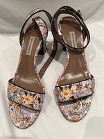 Top front view of the floral pattern Tabitha Simmons sandals showing open toe, ankle strap, and brown leather insole with brand label.