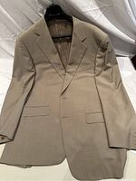 Front view of the men's tan Canali suit jacket showing buttoned front and flap pockets.