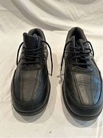 Front view of men's black FootJoy golf shoes showing toe box and lacing.