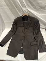 Front view of dark brown Ermenegildo Zegna men's suit jacket with white and tan pinstripes size 52R hung on hanger.