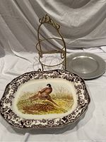 Photo showing front of tiered plate rack, turkey pheasant platter, and silver charger plate