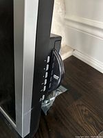 Close-up side view of the television showing built-in DVD player with visible DVD logo and control buttons on silver trim.