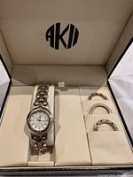 Anne Klein watch with two-tone metal band and three interchangeable rhinestone bezel rings in original box