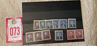 Black stock page with 12 mint Canada stamps from the 1950s showing various Prime Ministers.