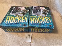 Two unopened wax boxes of 1990-91 O-Pee-Chee Canada NHL hockey cards arranged side by side.